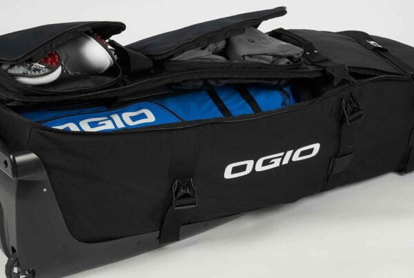 A golf travel bag filled with gear, featuring the dingo wheeled design for easy transportation.