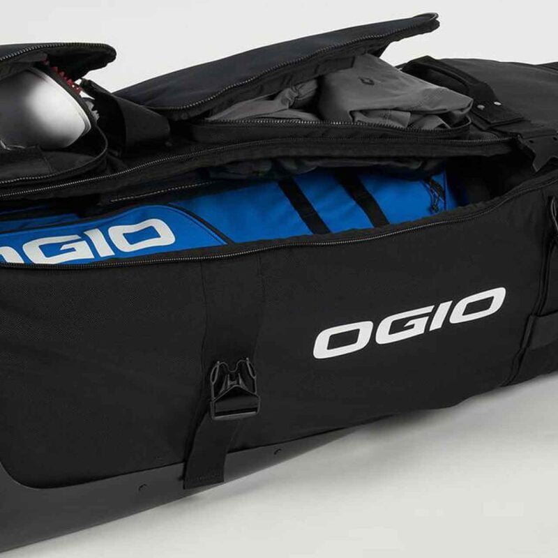 A golf travel bag filled with gear, featuring the dingo wheeled design for easy transportation.